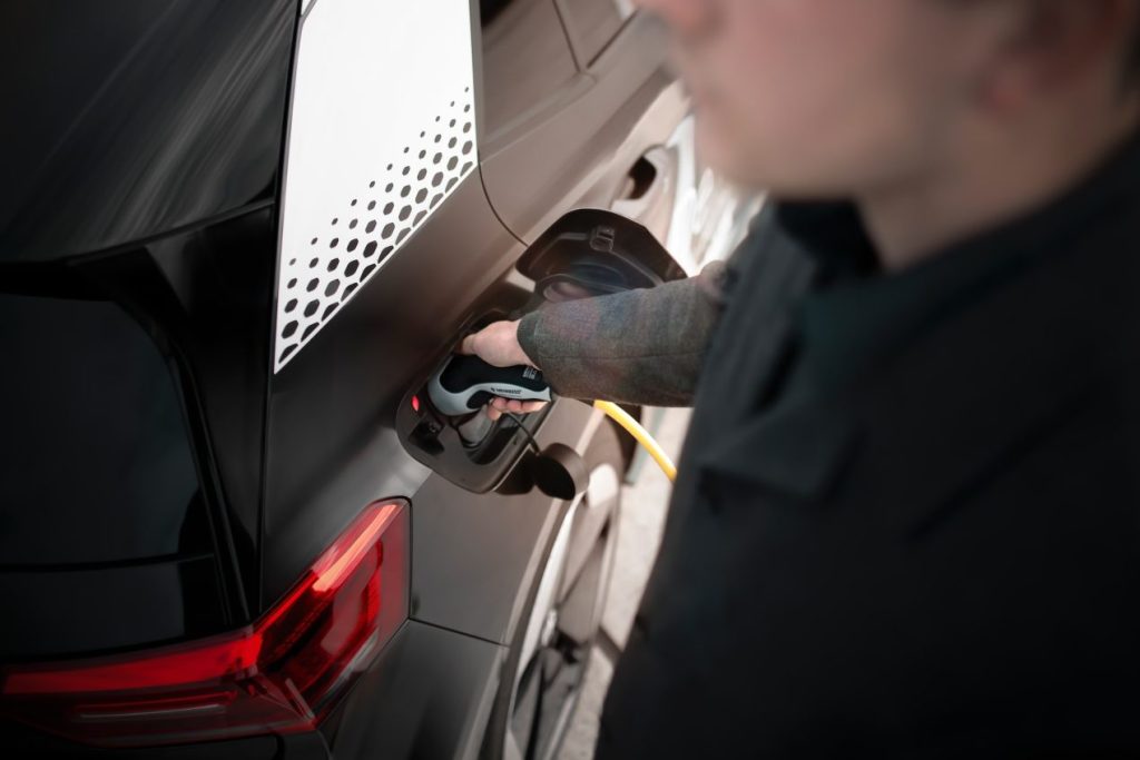 homme chargeant son véhicule électrique à une borne de recharge