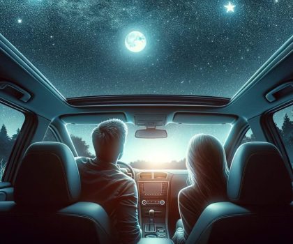 Young couple stargazing from inside their car